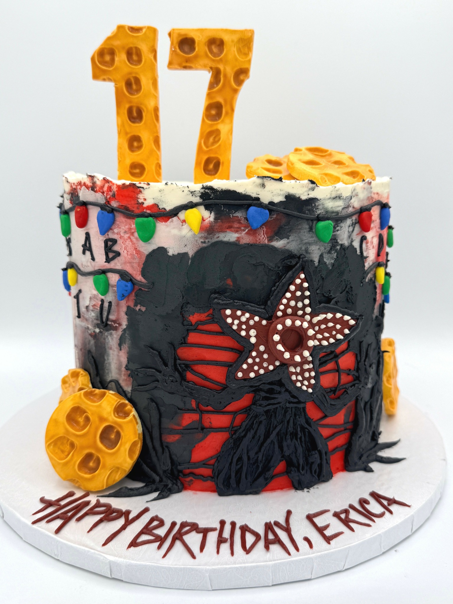 Colorful birthday cake with starfish decoration, number candles 17, and birthday message on white base.