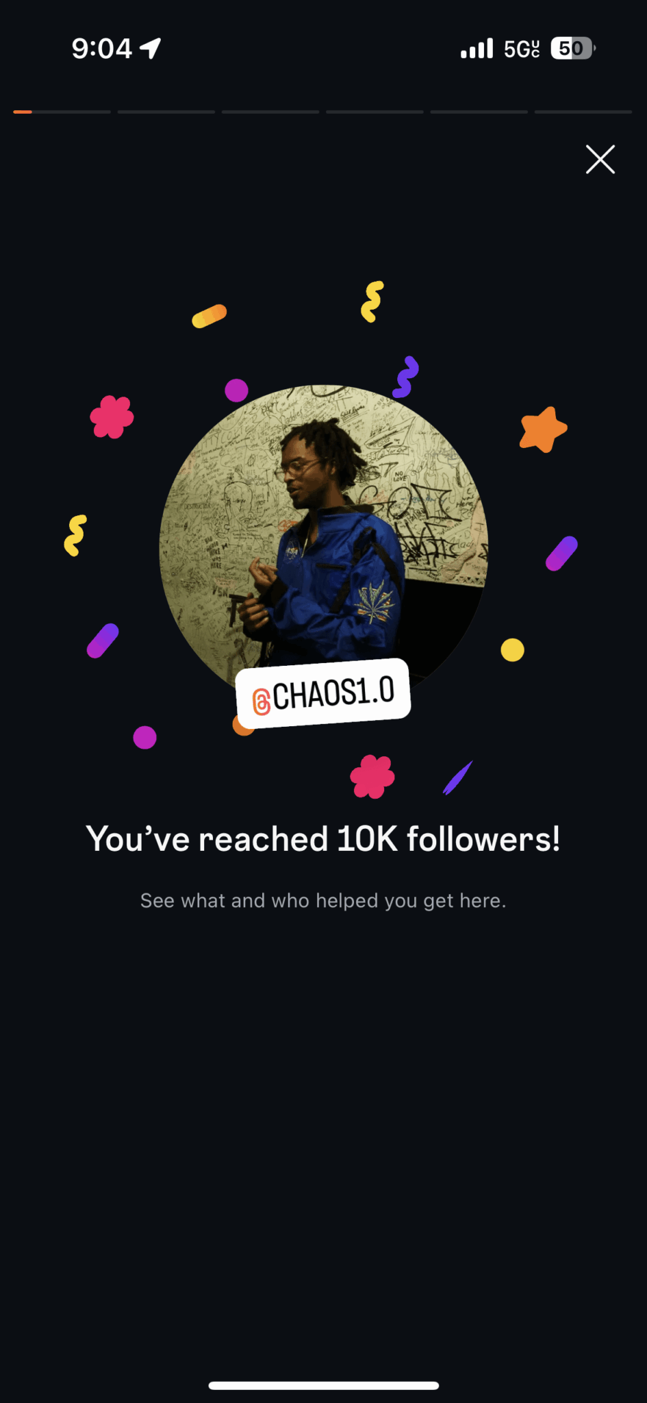 Person with curly hair in a blue jacket standing outdoors, celebrating reaching 10K followers, surrounded by colorful confetti.