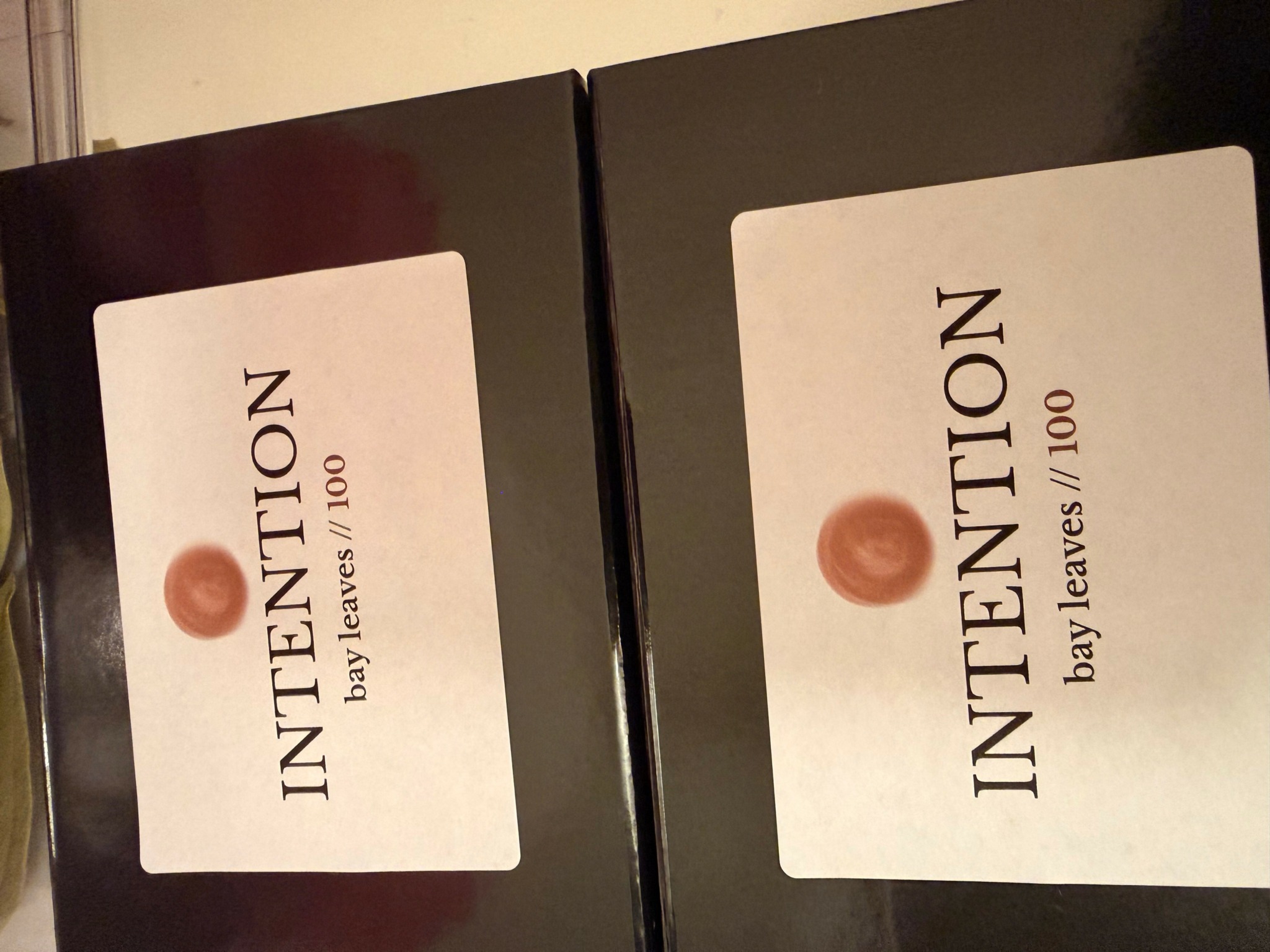 Two boxes with white labels reading 'INTENTION' and 'bay leaves / 100'.