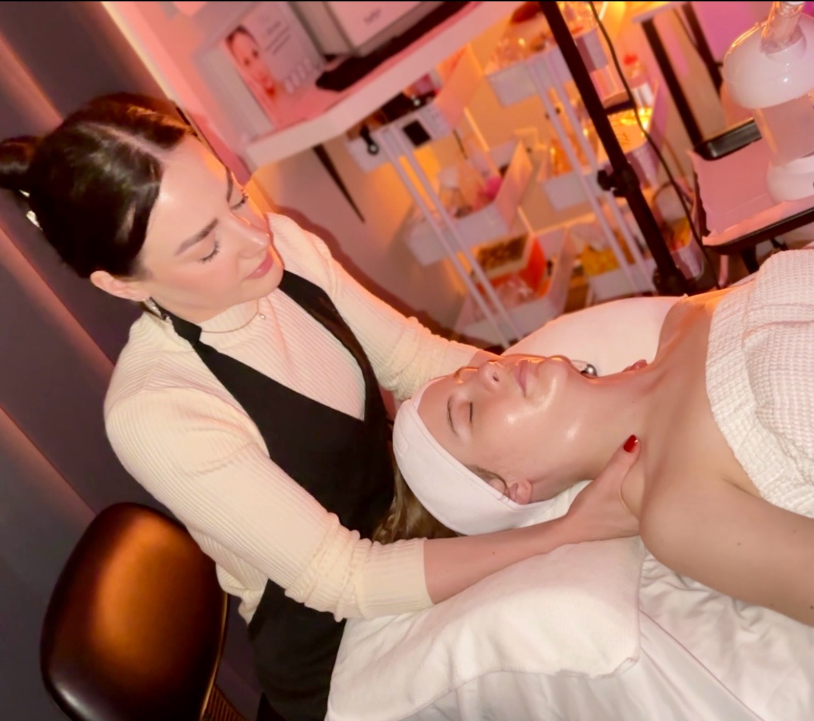 Woman receiving facial treatment from a professional in a spa or clinic setting.