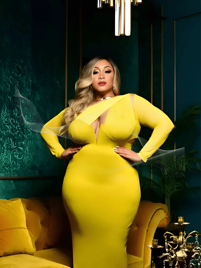 Woman in yellow dress standing in a room with dark green walls and yellow sofa.