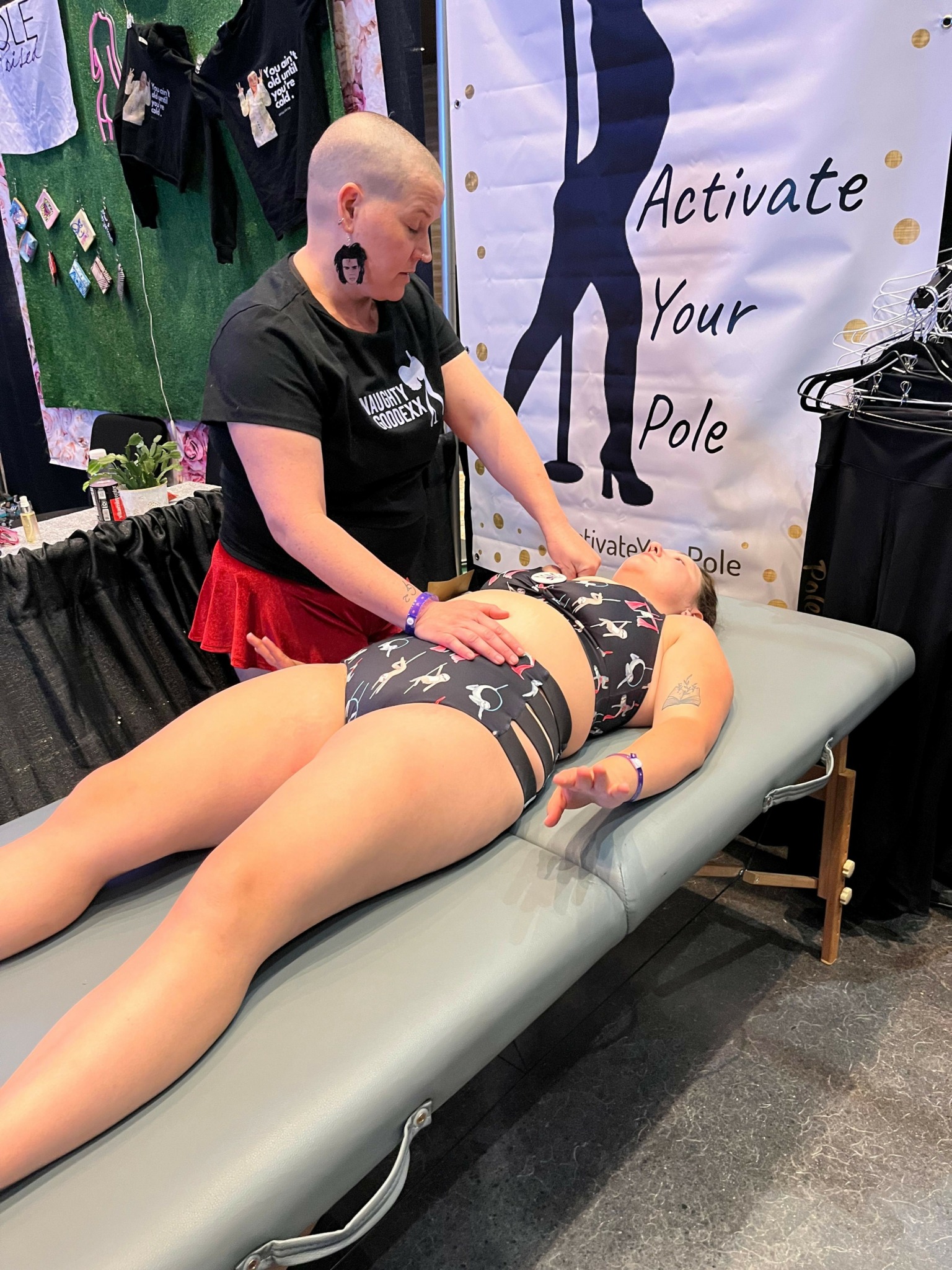 Person lying on a medical table, receiving a tattoo, with a banner in the background.