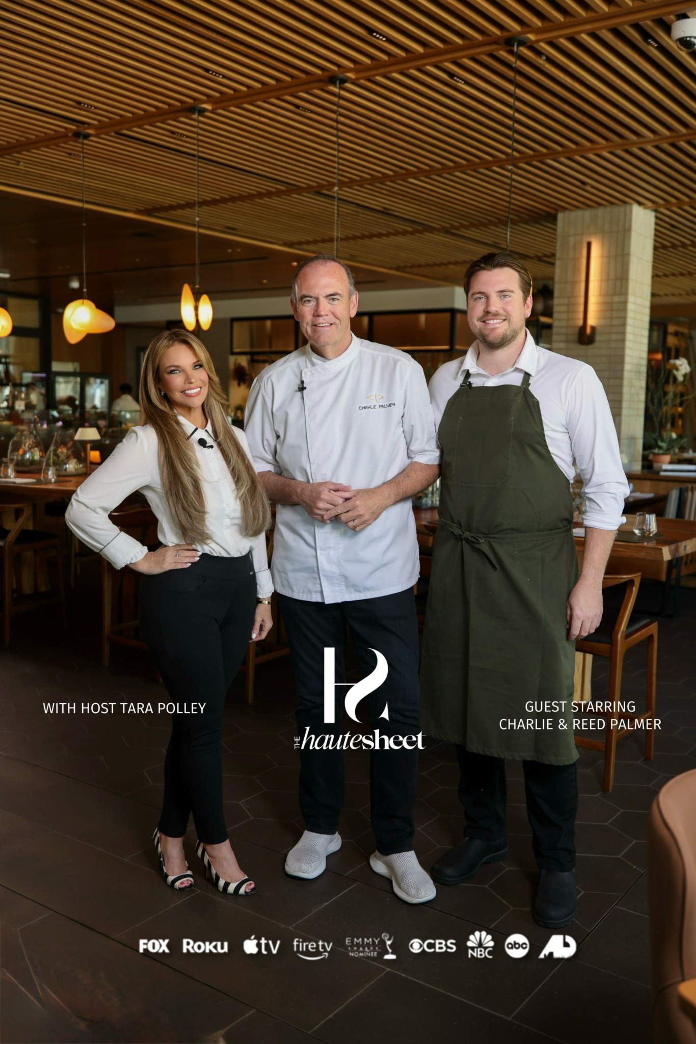 Three people standing in a restaurant, two men and one woman, with warm lighting and wooden ceiling.