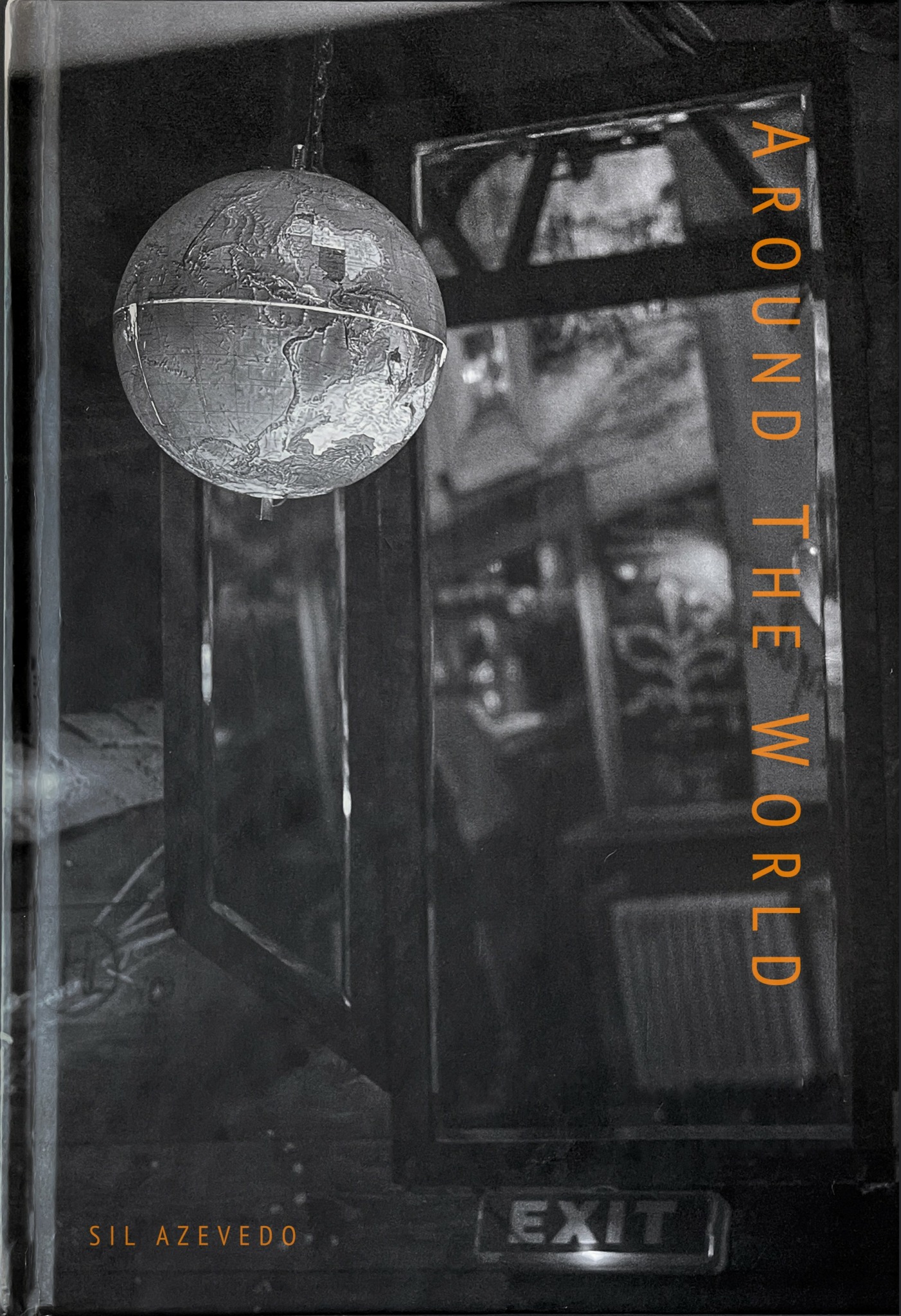 A spherical globe hanging inside a glass display case with the text 'AROUND THE WORLD' vertically on the right side.