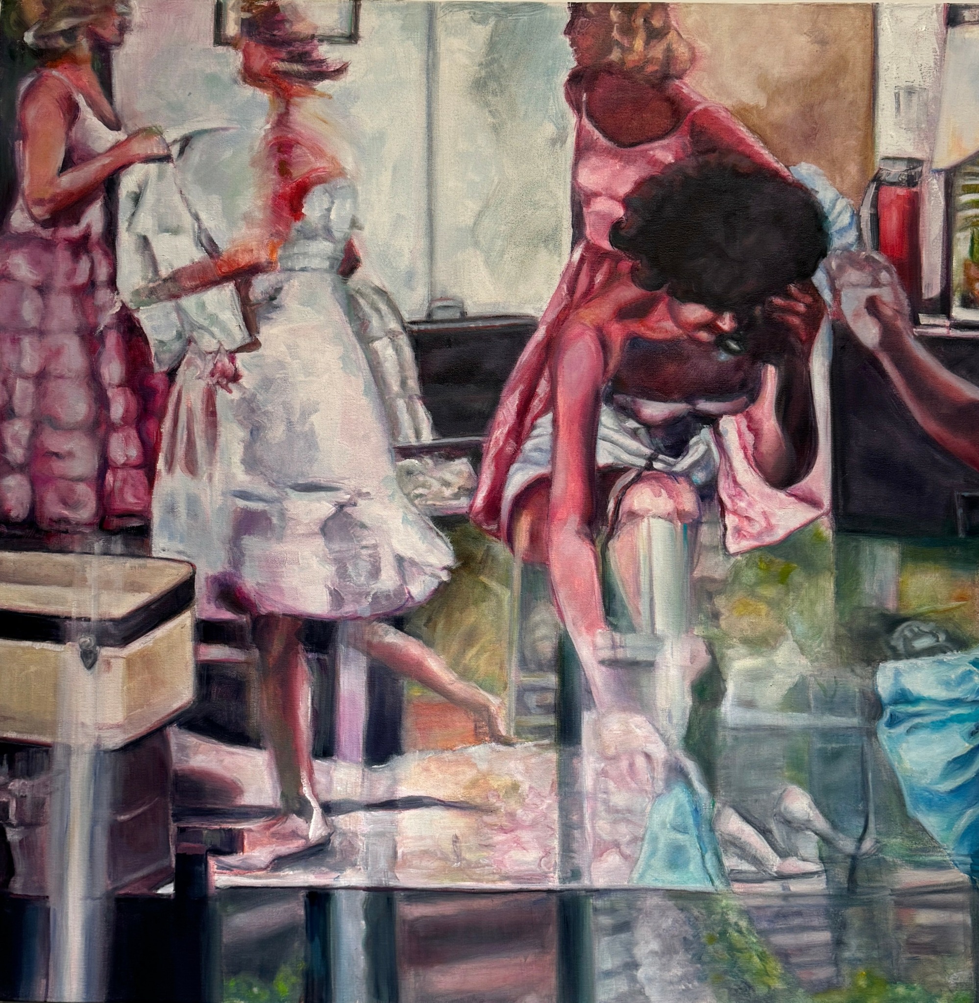 People gathered around a table with a cake, some standing and some sitting, in a lively setting.