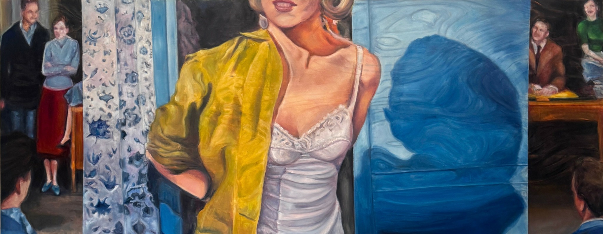 Person with blonde hair wearing a yellow jacket and white top, standing in front of blue and patterned background.