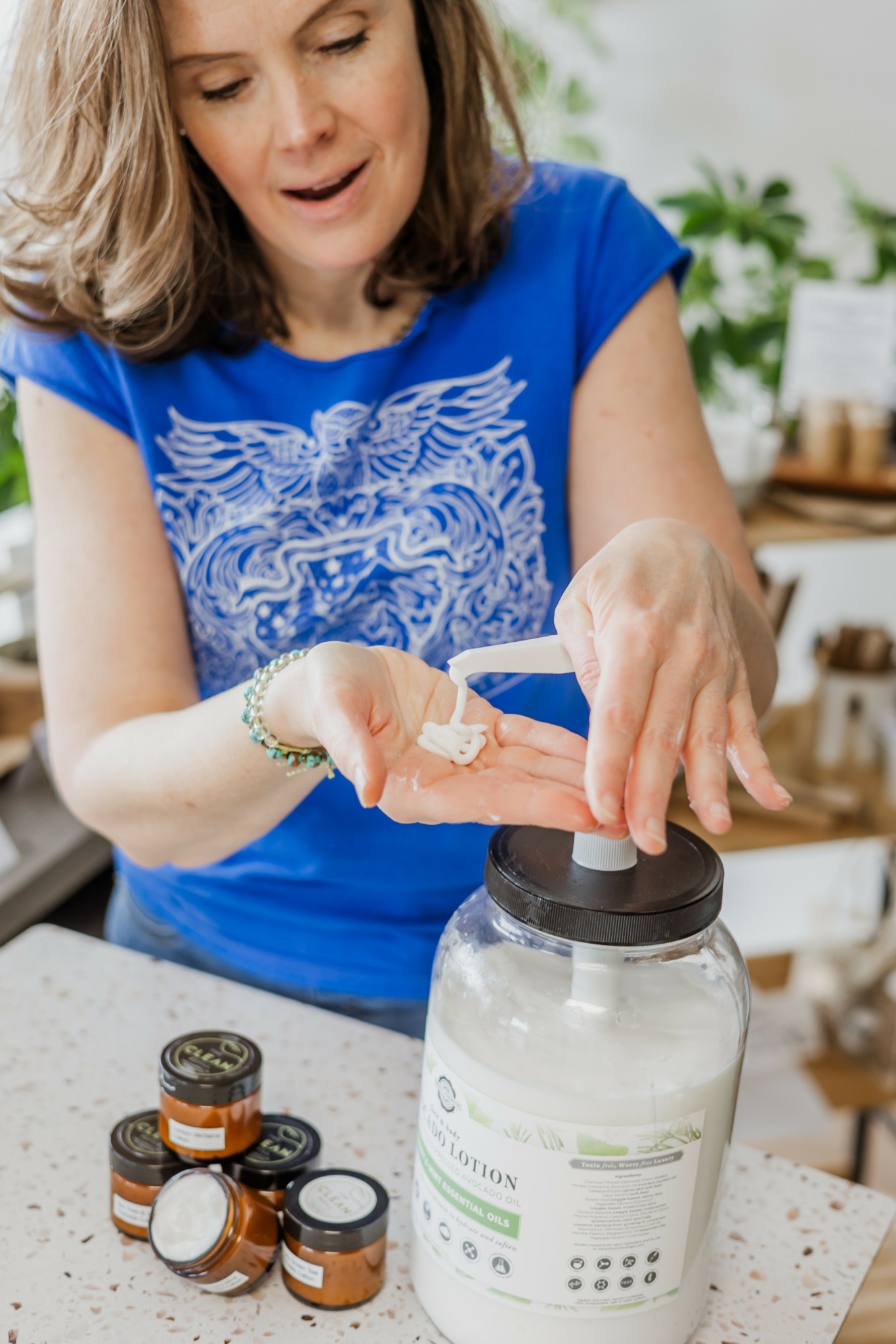 Woman pouring medication from a small bottle into a larger container in a kitchen setting.