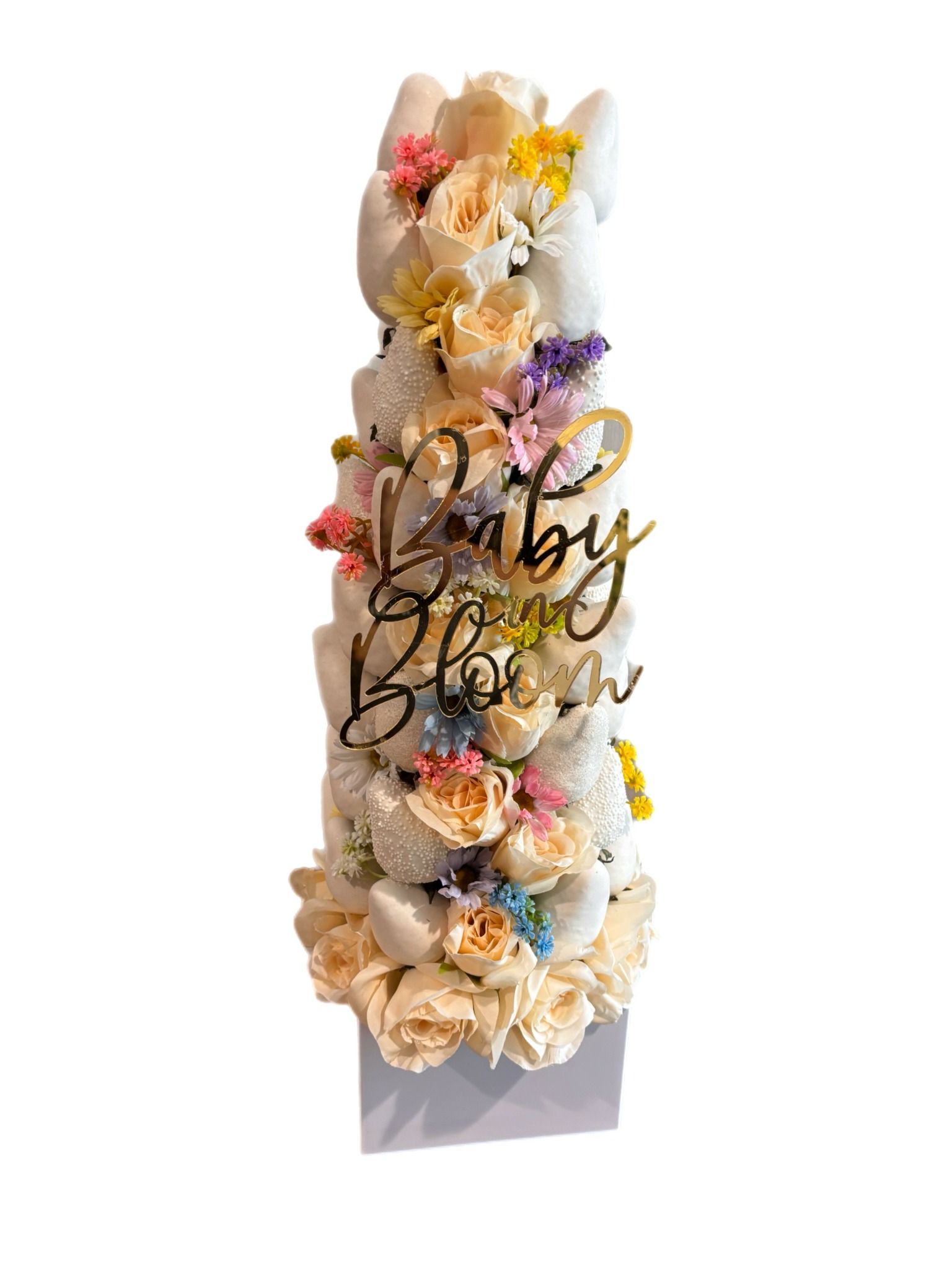 Tall floral arrangement with pastel-colored flowers and a gold 'Baby Shower' sign.