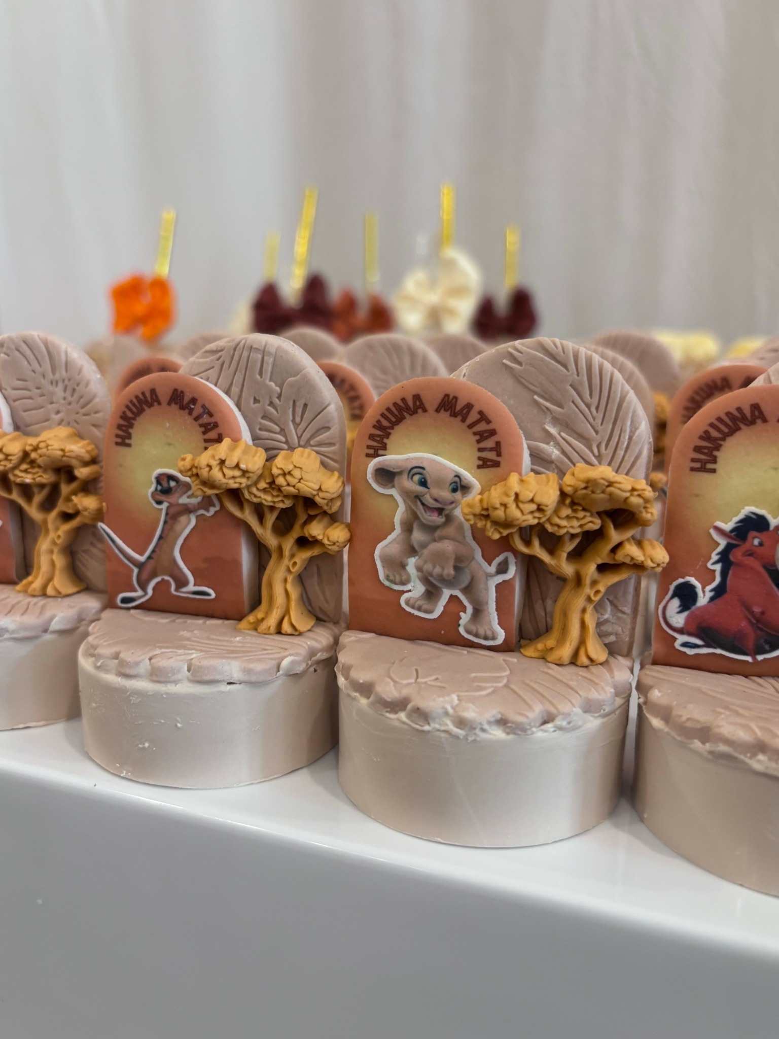 Four decorated cakes with dinosaur toppers and themed decorations, arranged on a white surface.