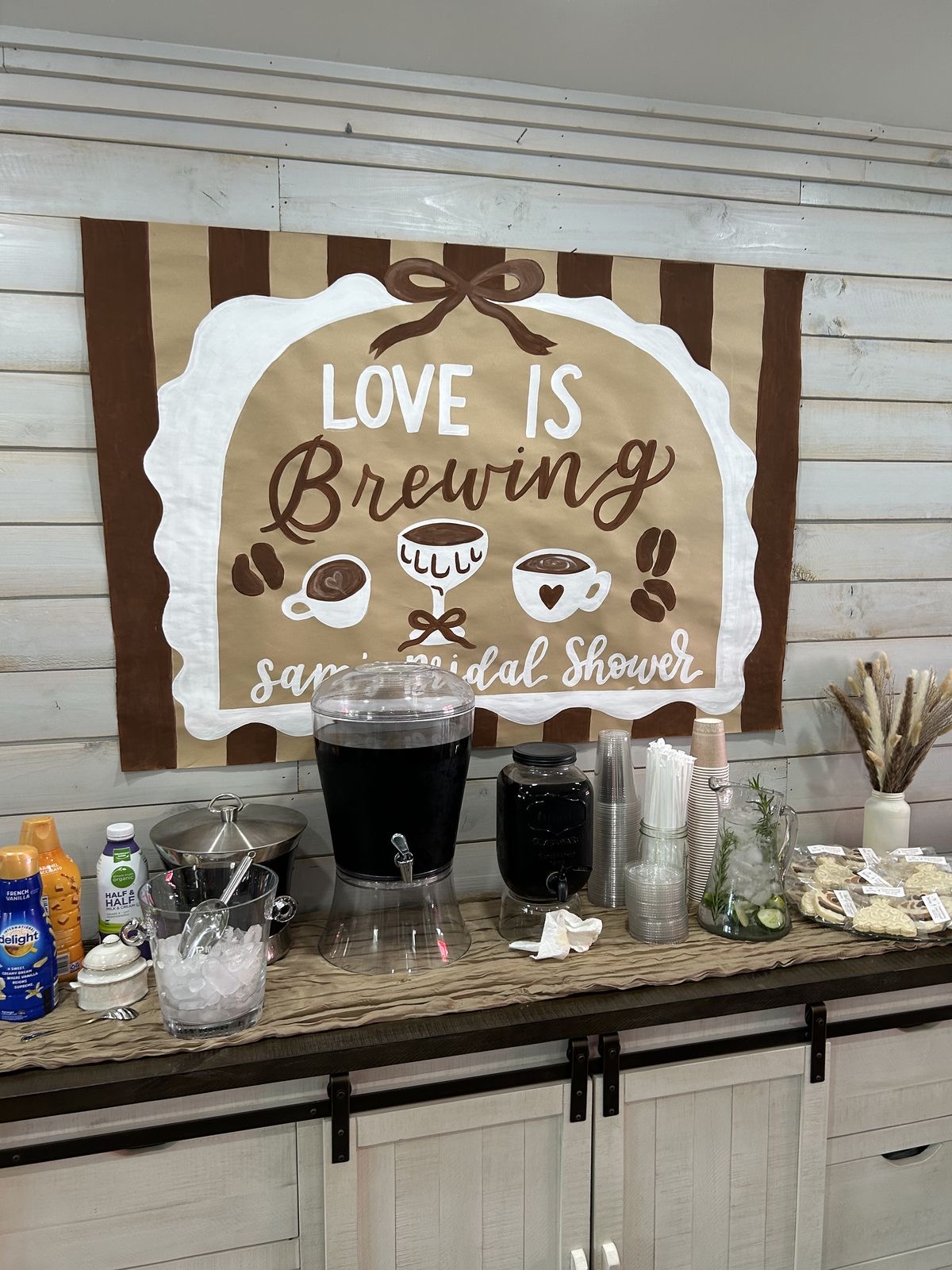 Beverage station with coffee and supplies in front of a sign that says 
