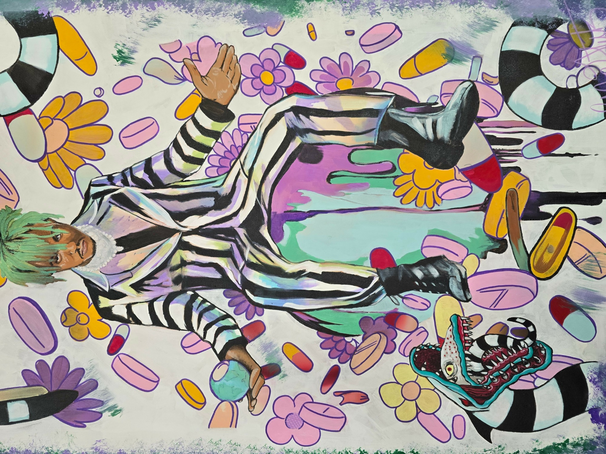 Person lying on colorful floral and abstract background, wearing black and white striped outfit and black boots.