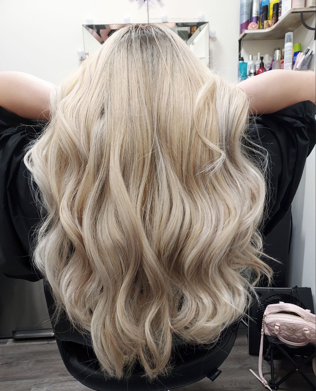 Back view of long, wavy, platinum blonde hair in a salon setting.