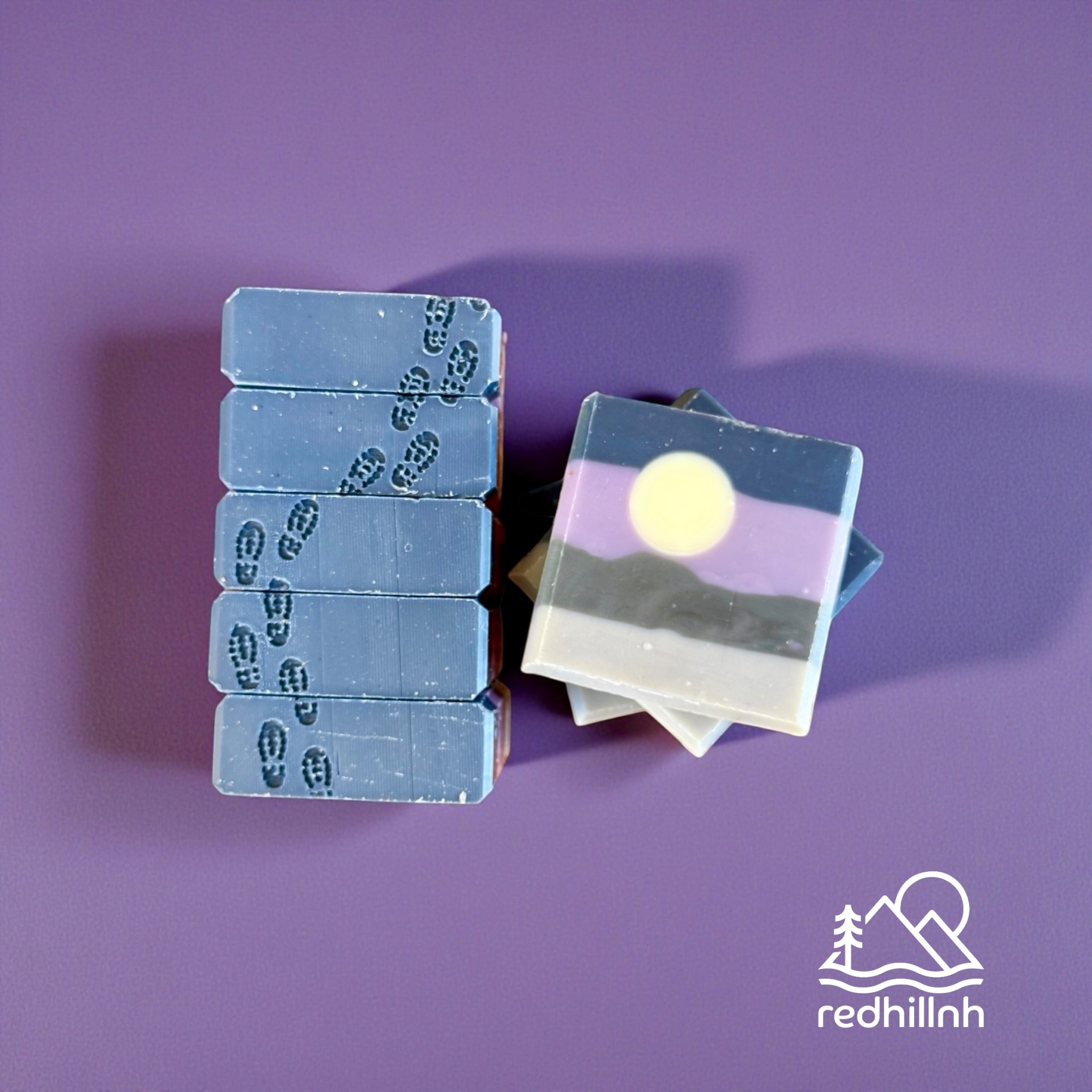 Stack of six blue and white tiles with a landscape painting, on a purple surface with a logo in the corner.
