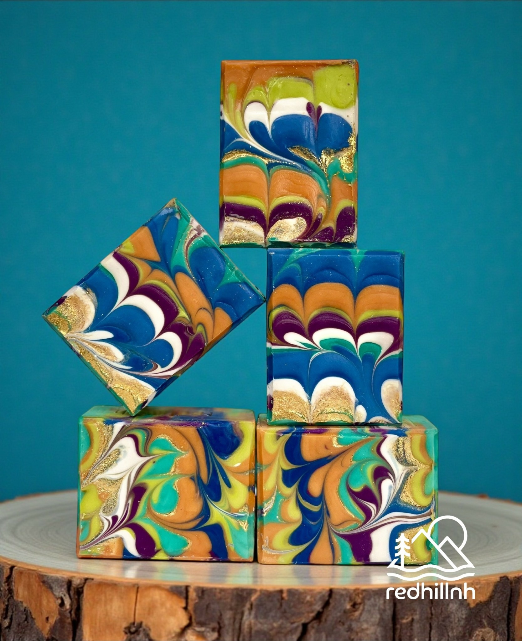 Six colorful marbled cubes arranged in a pyramid on a wooden surface against a blue background.