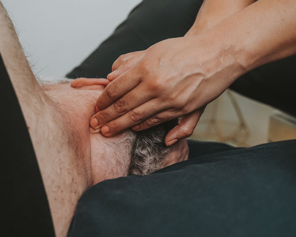 Close-up of hands touching a person's lower abdomen and groin area.