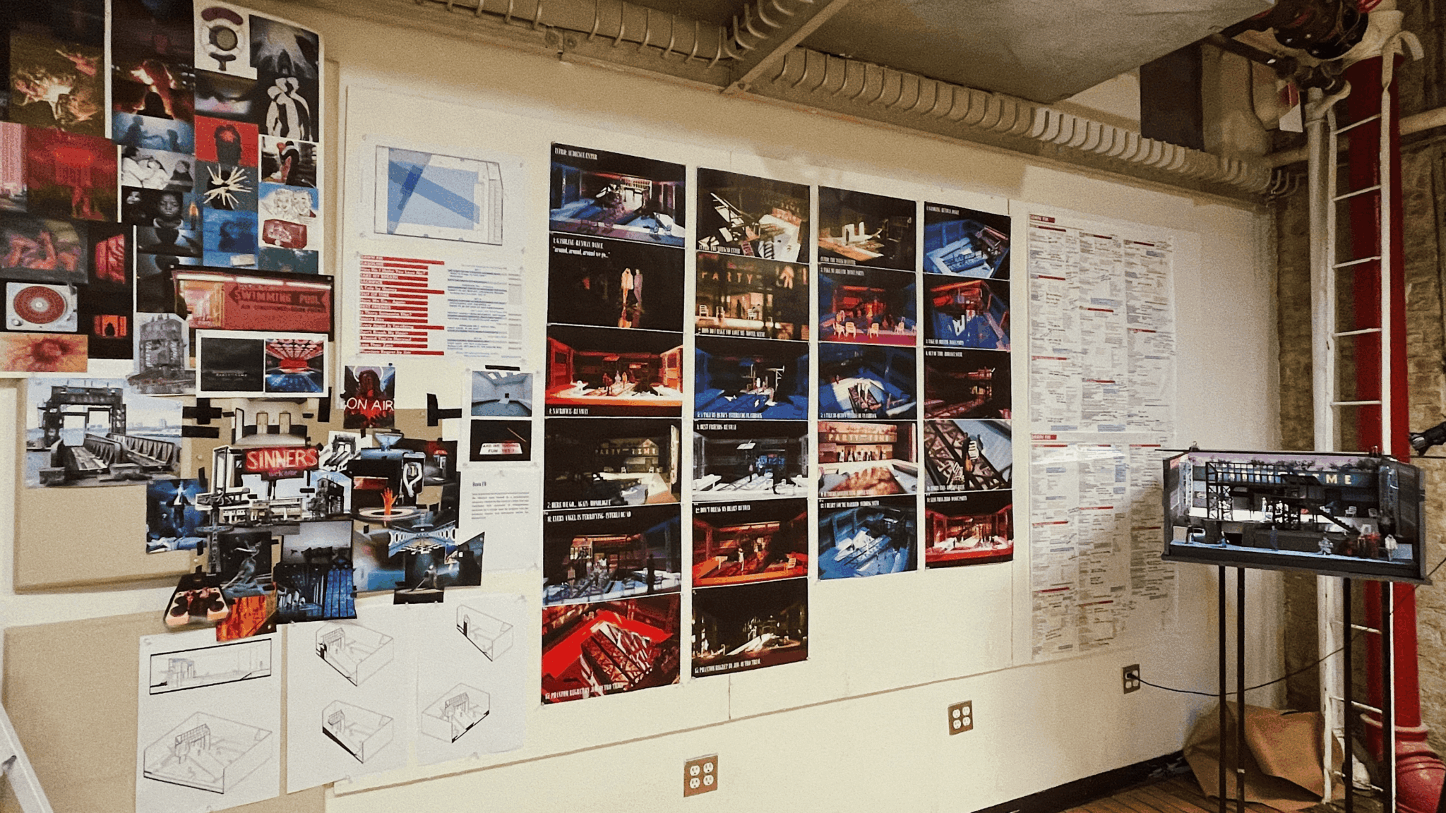 Exhibition wall with photographs, posters, and information panels, and a display case on a stand.