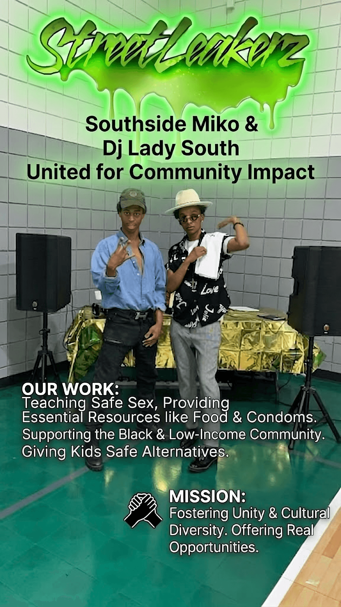Two young boys standing in front of a wall with green neon sign, holding microphones, with speakers and gold-covered objects nearby.