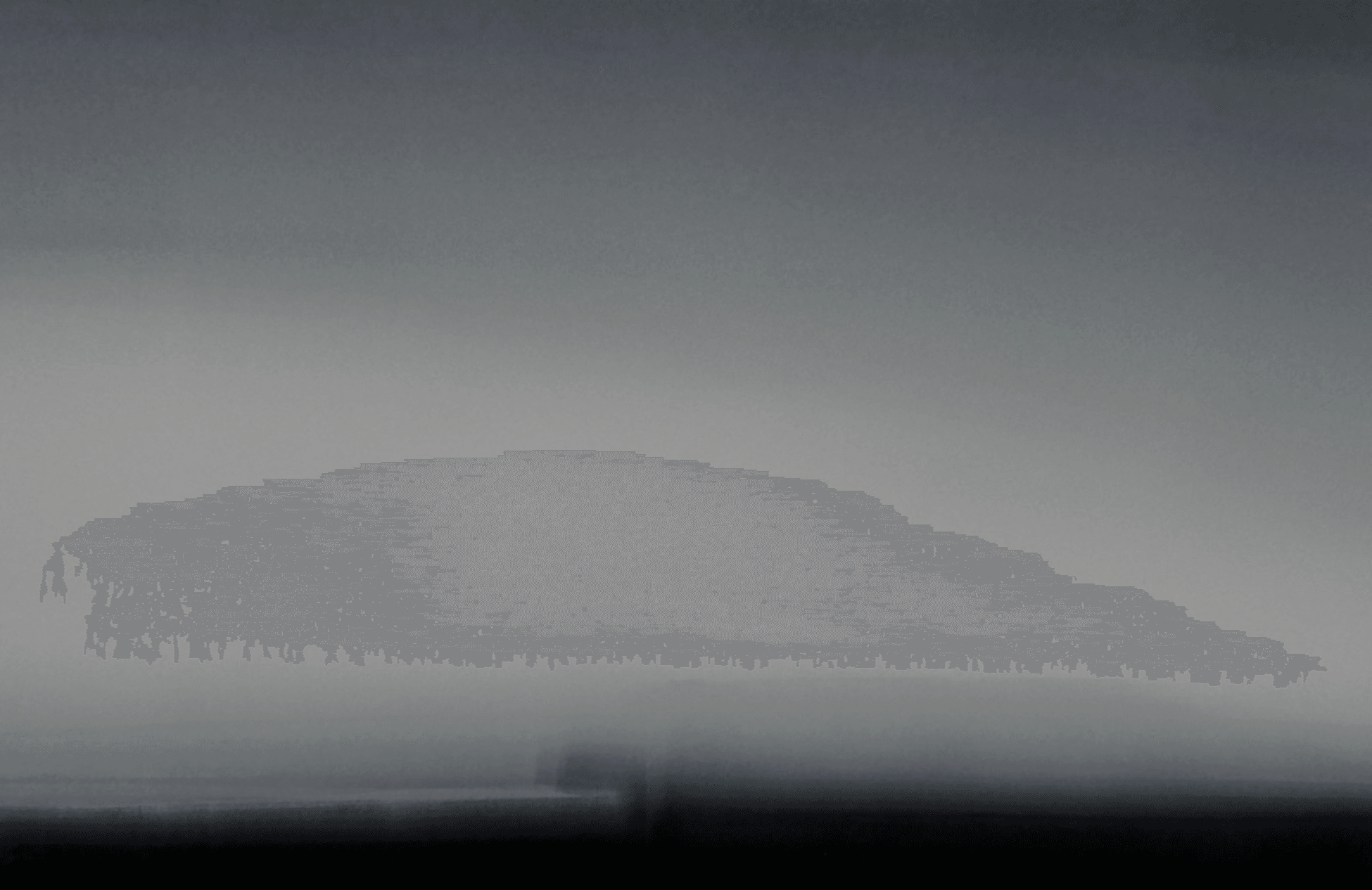 Blurred image with gradient shades of gray and black, no distinct objects visible.