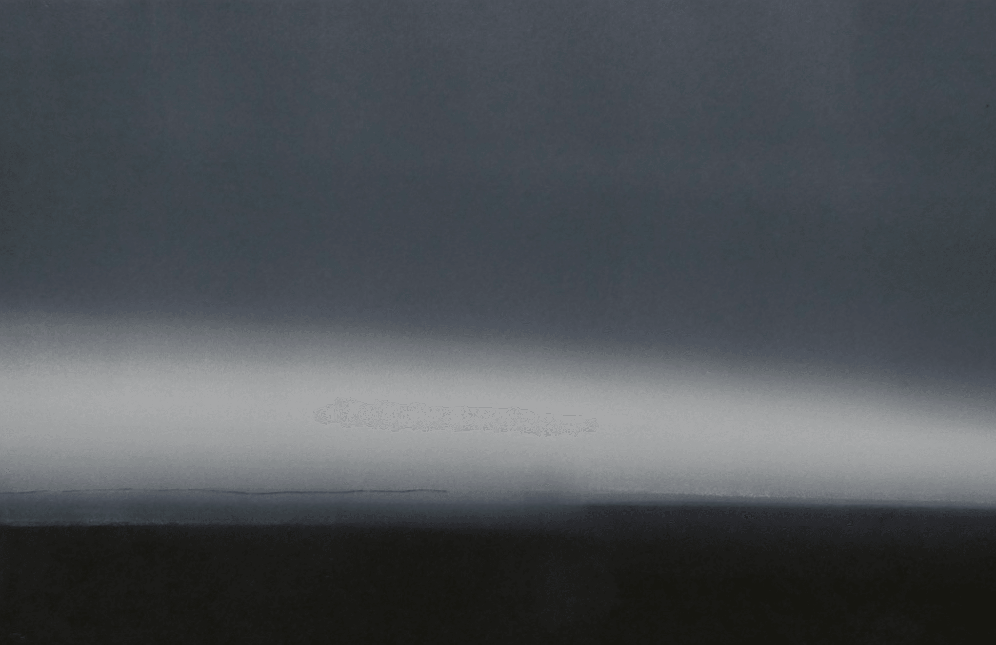 Dark sky with a bright horizontal streak, possibly a light or reflection, above a dark landscape or horizon.