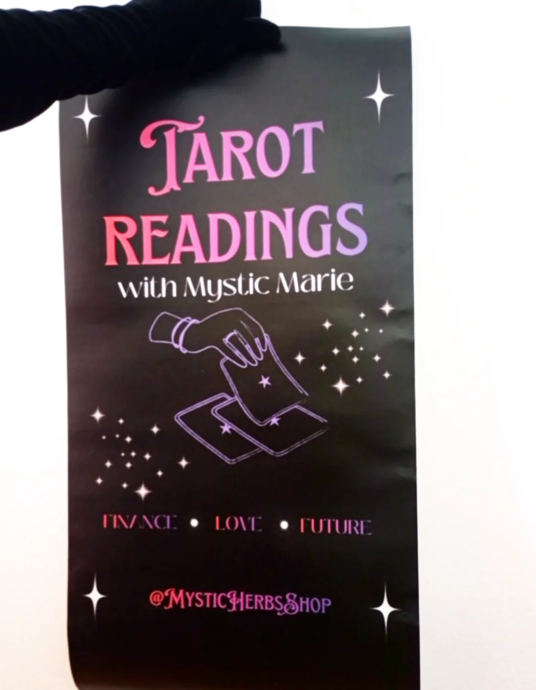 Black tarot reading book cover with pink and purple text and a hand drawing on a card.