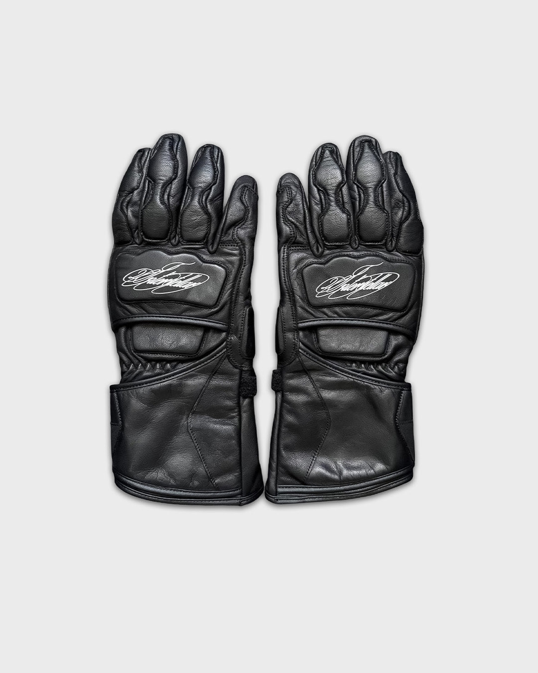 Pair of black leather gloves with logo on the back, laid flat on a light background.