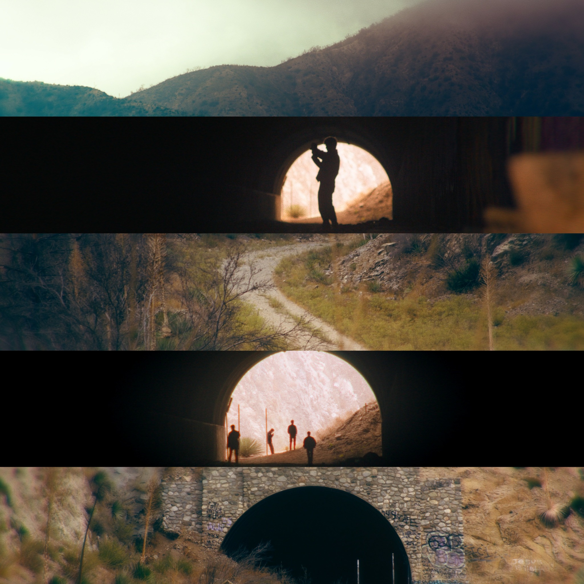 Silhouette of a person standing in a circular tunnel opening with a bright background, surrounded by landscape.