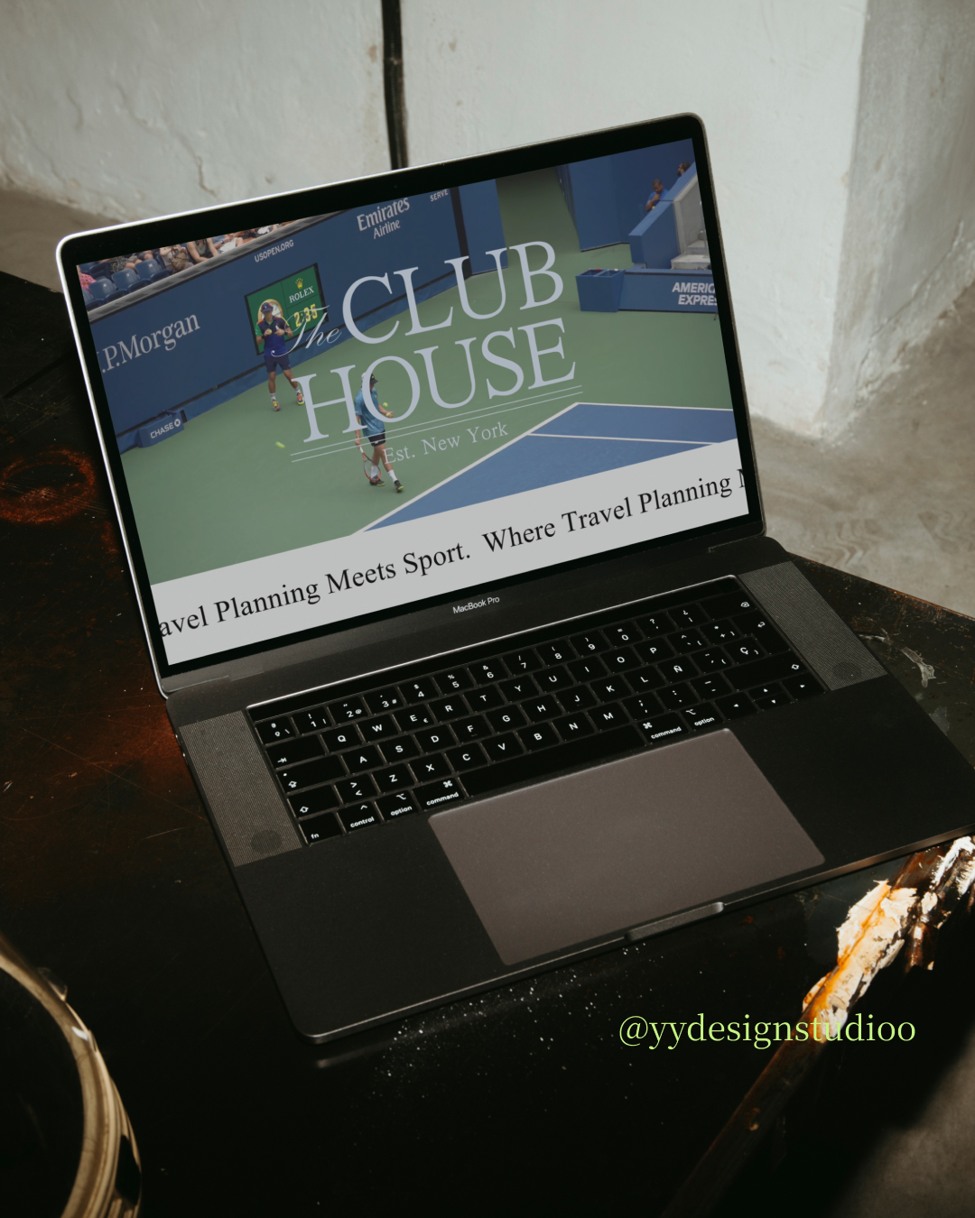 Laptop on table displaying a website with the text 'CLUB HOUSE' and a tennis court image.