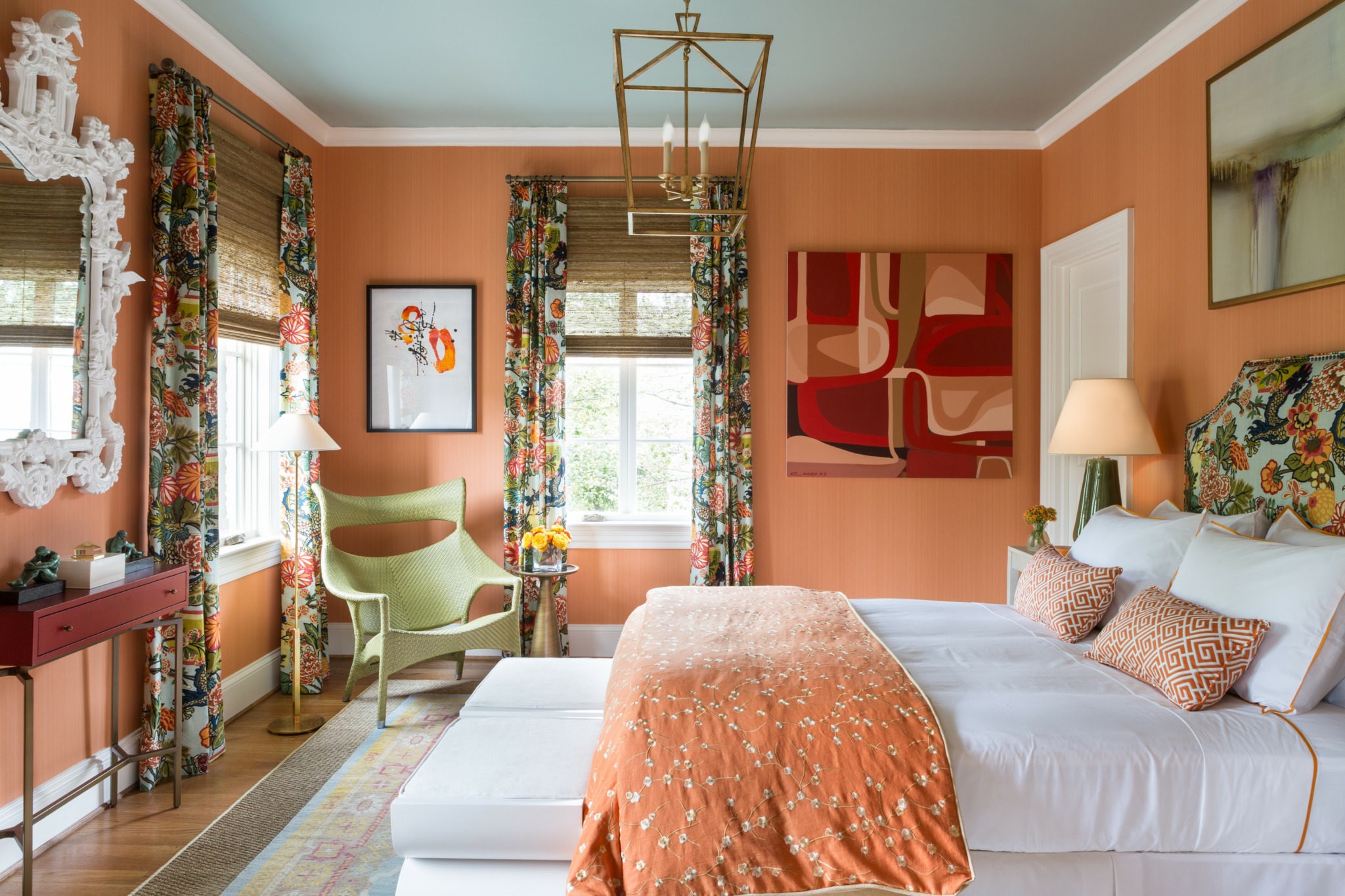 Bedroom with bed, pillows, curtains, armchair, window, and wall art, decorated in warm tones and vintage style.